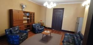 sala de estar con 2 sillas y mesa en La Casona del Buen dormir en Valdivia