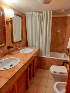 a bathroom with two sinks and a toilet and a shower at Cal Ferrer Habitatge Rural in Cava