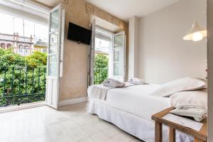 a bedroom with a bed and a large window at Hotel Boutique Elvira Plaza in Seville