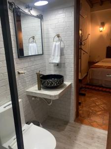 baño con lavabo, espejo y cama en Bohemia Hotel Boutique, en Mompox
