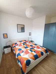 sypialnia z łóżkiem z kolorową kołdrą w obiekcie Appartement coeur centre-ville cosy et chaleureux rue Carnot w mieście Châlons-en-Champagne