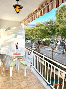 einen Balkon mit einem Tisch und Stühlen sowie Straßenblick in der Unterkunft APARTBEACH SAYONARA 125 Climatizado y Piscina in Salou