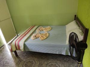 a small bed with towels on it in a room at Pousada Sol in Cavalcante