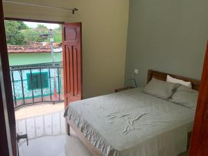 een slaapkamer met een bed naast een balkon bij apartamentos Casa Amarilla in Granada