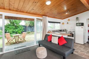 a living room with a couch and a kitchen at Waikanae Beach Motel in Gisborne