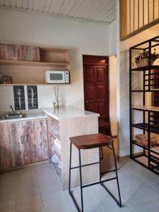 a kitchen with a counter and a sink and a stool at Hotel Villa Margarita in Flores