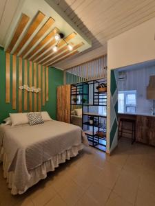 1 dormitorio con cama y pared verde en Hotel Villa Margarita, en Flores