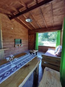 a room with a bed and a couch and a tv at Riberas del Azul in Lago Puelo
