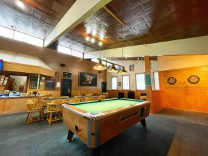 Valhalla Inn في New Denver: طاولة بلياردو في غرفة مع طاولات وكراسي