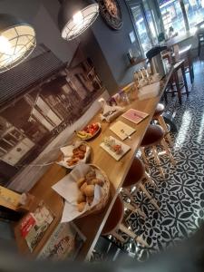 una larga mesa de madera con platos de comida. en Brasserie & Logies De Pijl, en Malinas