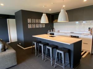 a kitchen with a island with bar stools at Mountain Vista Retreat - Apartment 2 in Twizel