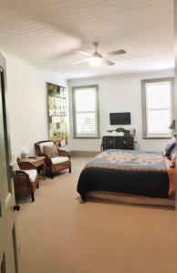 a bedroom with a bed and a couch and a chair at The Nunnery Boutique Hotel in Moss Vale