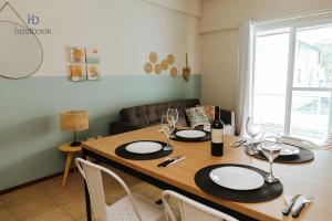 uma sala de jantar com uma mesa de madeira com cadeiras em Apto a 200 m da praia do bosque - WIFI 200MB - TV Smart - Cozinha equipada - Garagem - Ar condicionado em Rio das Ostras