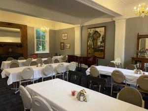 a room full of tables and chairs with white table cloth at The Royal Mail Hotel Braidwood in Braidwood