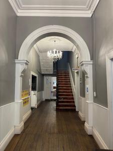 a hallway with a chandelier and stairs in a building at The Royal Mail Hotel Braidwood in Braidwood +14 photos