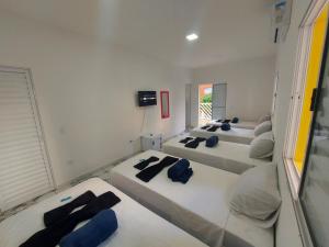 a room with four beds with blue pillows on them at Hospedaria in Guarujá