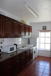 een keuken met een spoelbak en een magnetron bij Baleal Holiday Apartment in Baleal