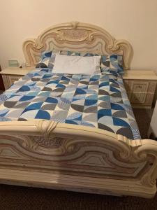 uma cama com uma colcha azul e branca em Busy Bee - Guest House - Self Service em Leigh