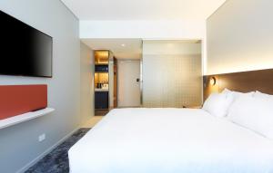 
a bedroom with a white bed and white walls at Holiday Inn Express Adelaide City Centre, an IHG Hotel in Adelaide
