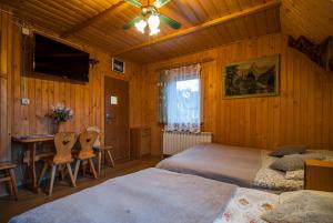 ein Schlafzimmer mit zwei Betten und einem Schreibtisch und einem Fernseher in der Unterkunft Pokoje u Sarnowskich in Kościelisko