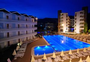 a swimming pool in front of a hotel at night at Panorama Hotel - All Inclusive in Alanya
