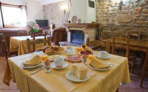 una mesa con comida en una habitación con chimenea en Agroturismo Ibarre, en Anzuola