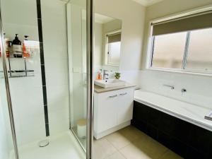 a bathroom with a shower and a sink and a tub at Goodenia Vibes in Inverloch +13 photos