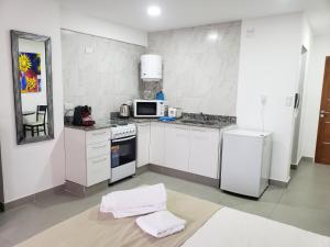 een keuken met witte kasten en een witte koelkast bij Depto Guemes in Salta