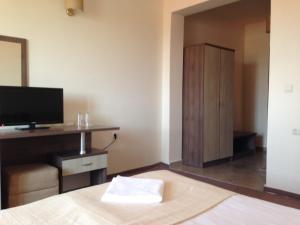 a bedroom with a bed with a television and a cabinet at Hotel Laguna in Lozenets
