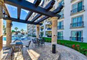 a patio with chairs and tables in front of a building at Perfect location - Puerta Cabo Village 500 steps to the beach & resorts in Cabo San Lucas