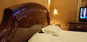 um quarto com uma cama de madeira e almofadas brancas em Sea Haven Resort Motel em Southampton