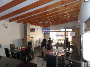 a dining room with tables and chairs and a television at Hotel Portal del Norte in Copiapó