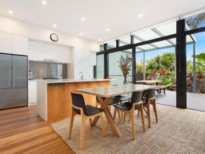 a kitchen with a wooden table and chairs at Your Luxury Escape - Kiah 11 Beach House Ocean views in Byron Bay