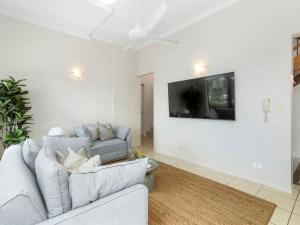 un salon avec un canapé et une télévision à écran plat dans l'établissement Currumbin Beachfront Haven, à Gold Coast