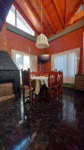 una sala da pranzo con tavolo, sedie e lampadario pendente di Las Retamas a Villa Pehuenia