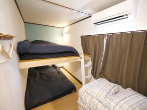 a small room with two bunk beds and a window at 民泊 Lokahi海まで徒歩約2分の好立地 敷地内に居酒屋あります in Iioka
