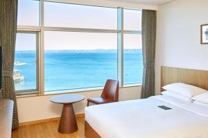 ポハンにあるLahan Hotel Pohangのベッドと大きな窓が備わるホテルルームです。