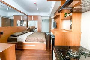 Il comprend une petite chambre avec un lit et une cuisine. dans l'établissement RedLiving Apartemen Green Lake View Ciputat - Juragan Rooms Tower B with Fast Wifi, à Pondokcabe Hilir