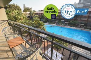 a resort balcony with a swimming pool and a sign that says safe travels at Basaya Beach Hotel & Resort in Pattaya