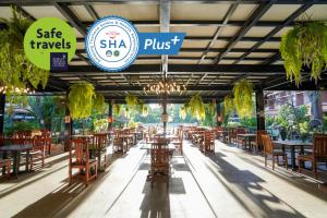 a restaurant with tables and chairs and a sign that reads safe travels shka plus at Basaya Beach Hotel & Resort in Pattaya