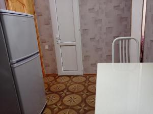 a kitchen with a white refrigerator and a table at Bizim Ev hostel in Naftalan