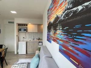 una sala de estar con una gran pintura en la pared en Brisas del Olivia en Ushuaia