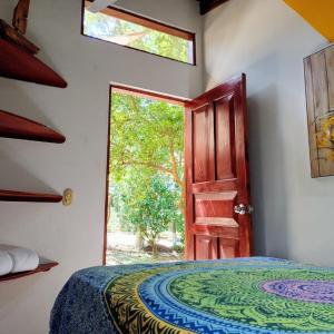 a bedroom with a bed and an open door at Nasu Lodge in La Cruz