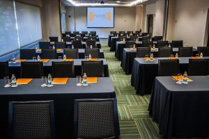 a conference room with tables and chairs and a screen at Hotel Novit in Mexico City