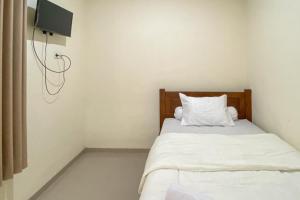 Postel nebo postele na pokoji v ubytování Nipa Guest House near Universitas Widyagama Mitra RedDoorz