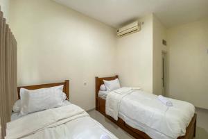 Postel nebo postele na pokoji v ubytování Nipa Guest House near Universitas Widyagama Mitra RedDoorz