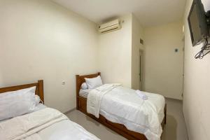 Postel nebo postele na pokoji v ubytování Nipa Guest House near Universitas Widyagama Mitra RedDoorz