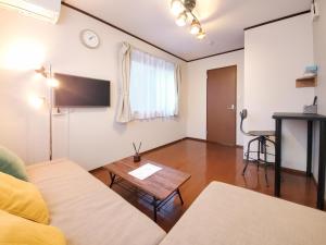 a living room with a couch and a table at nestay suite tokyo shibuya in Tokyo