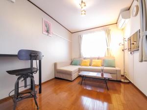 a living room with a couch and a chair at nestay suite tokyo shibuya in Tokyo