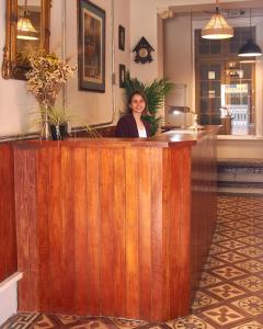 een vrouw die achter een houten toonbank in een salon staat bij Casa Porta in Lima